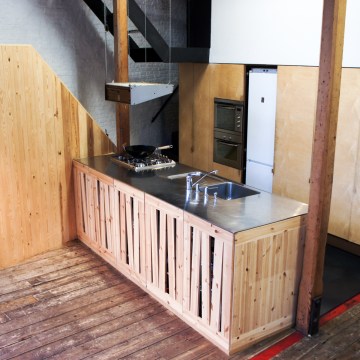 Atelier Antipode See-through kitchen doors in pine wood. The wooden laths are set up in an alternating zig zag pattern.