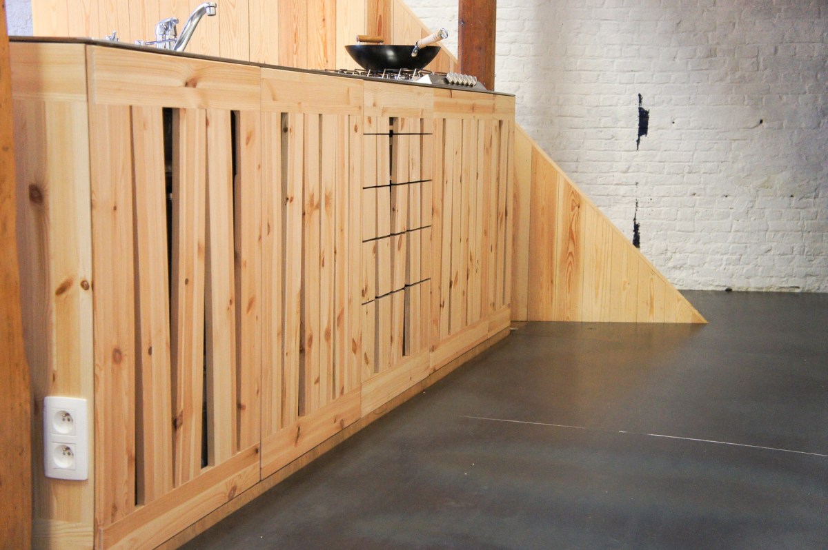 Atelier Antipode | See-through kitchen doors in pine wood. The wooden laths are set up in an alternating zig zag pattern.