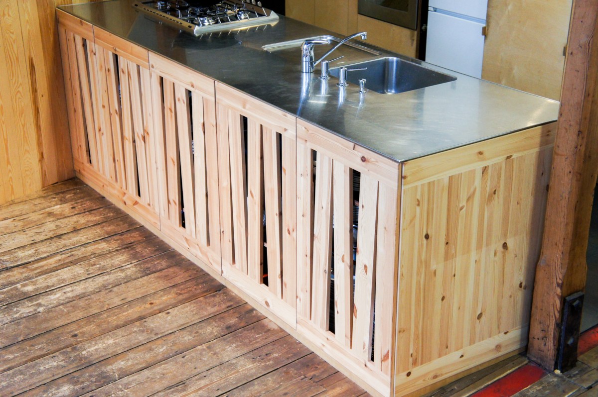 Atelier Antipode See-through kitchen doors in pine wood. The wooden laths are set up in an alternating zig zag pattern.