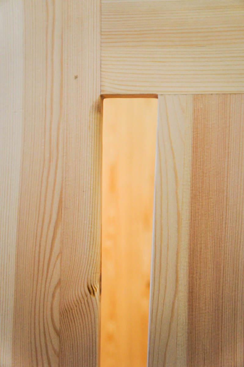 Atelier Antipode See-through kitchen doors in pine wood. The wooden laths are set up in an alternating zig zag pattern.