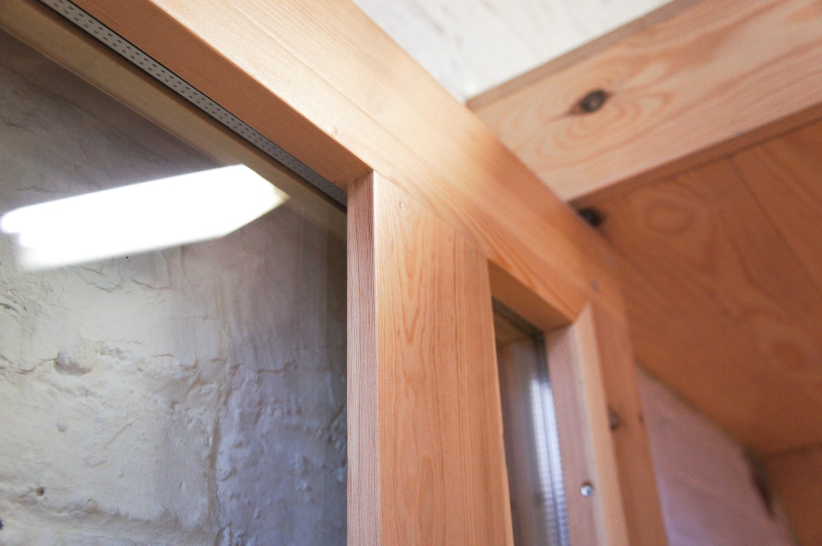 Atelier Antipode | See-through pivoting door in pine wood. The wooden laths are set up in an alternating zig zag pattern. Insulation glass.